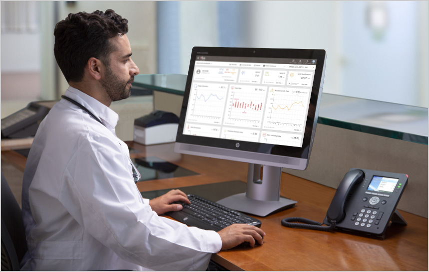 Clinician in white lab coat using a computer.